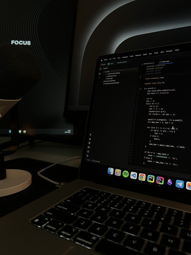 A dark workspace with a laptop displaying code