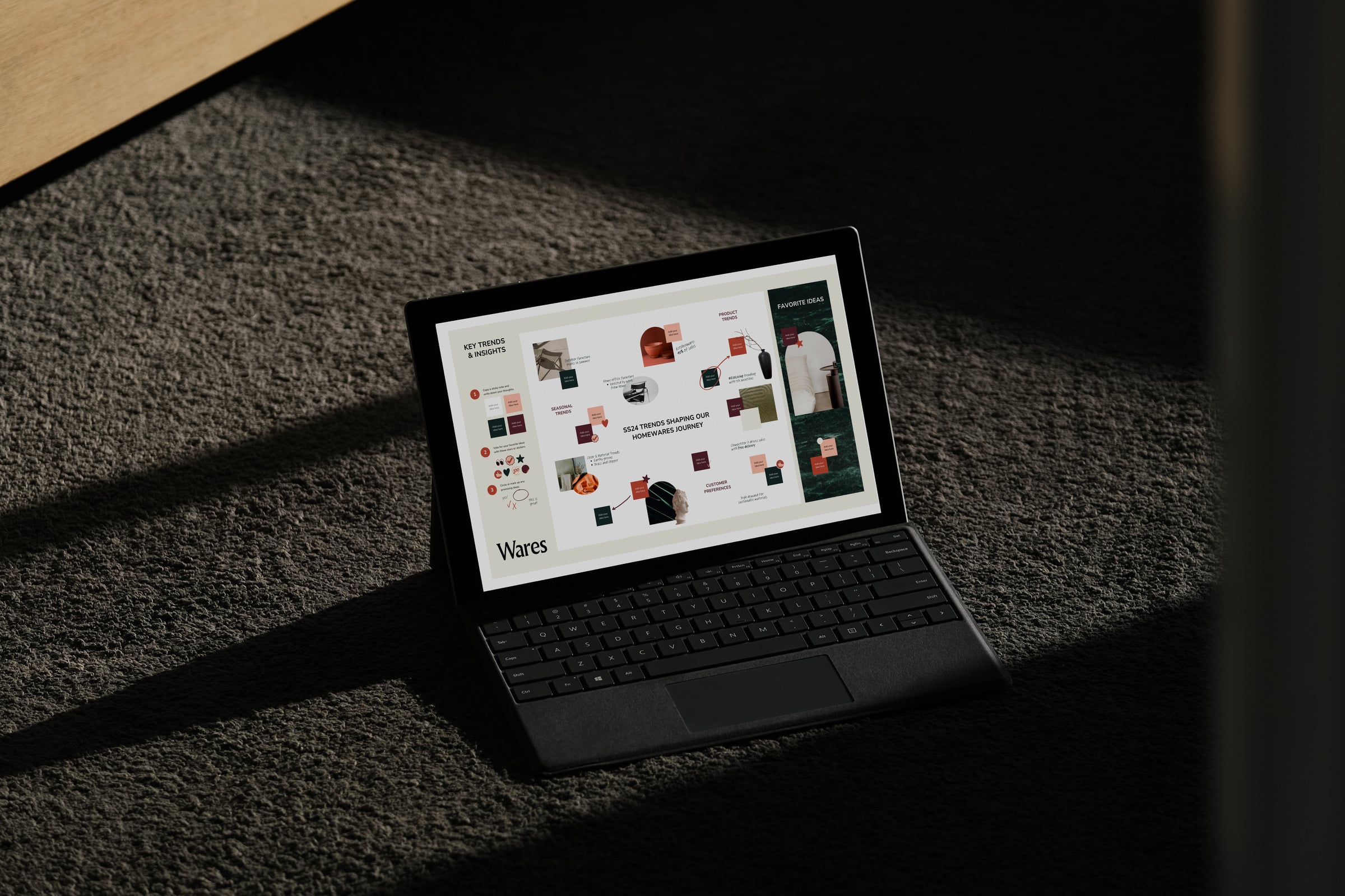 A laptop on a dark carpet, showing a visual moodboard